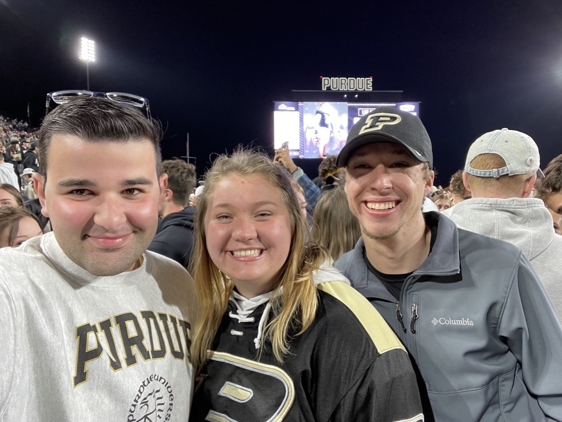 Taylor (far right), Kent Burkman and Hannah Radde storm the football field after Purdue beat Michigan State.